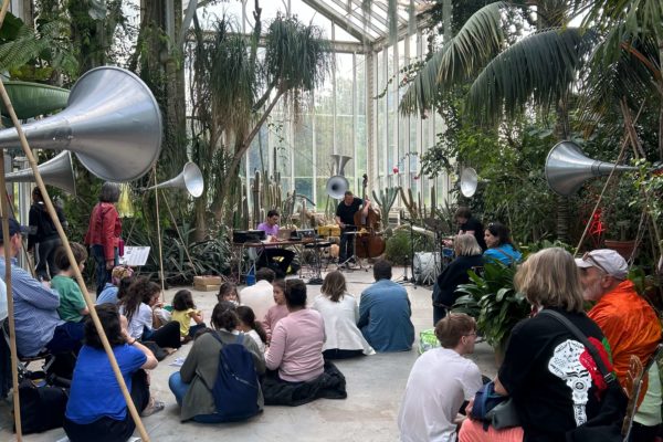 Public assis de dos dans une serre du Jardin botanique de Genève écoutant un concert lors de la Nuit des musées 2025