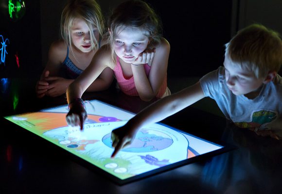 Jeune public touchant un grand écran tactile JEMA