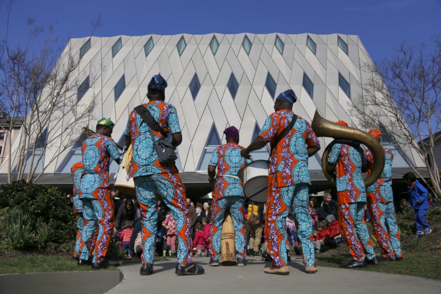Groupe de musique d'Afrique noire jouant devant la façade du MEG