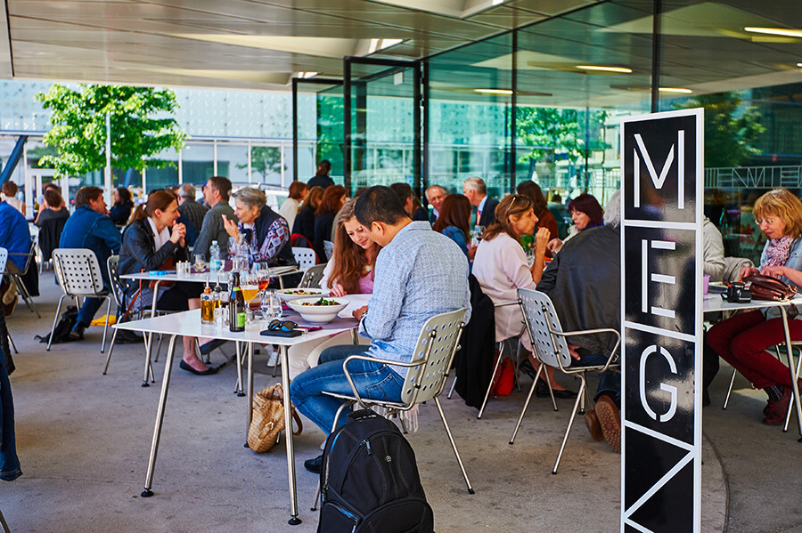 Public assis au café du MEG