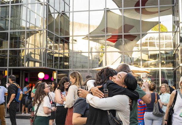 Public dans la cour du MICR avec un couple s’enlaçant au premier plan