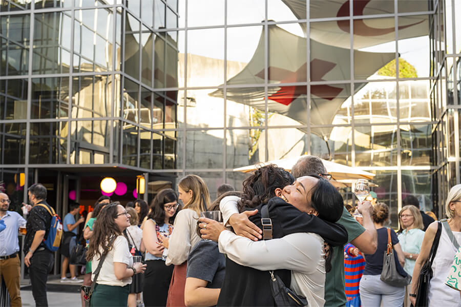 Public dans la cour du MICR avec un couple s’enlaçant au premier plan