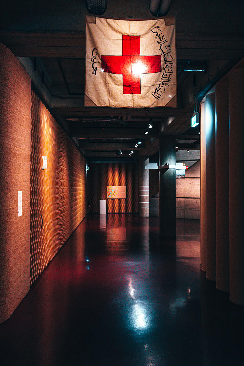 Drapeau de la Croix-Rouge avec des inscriptions tendu dans un couloir