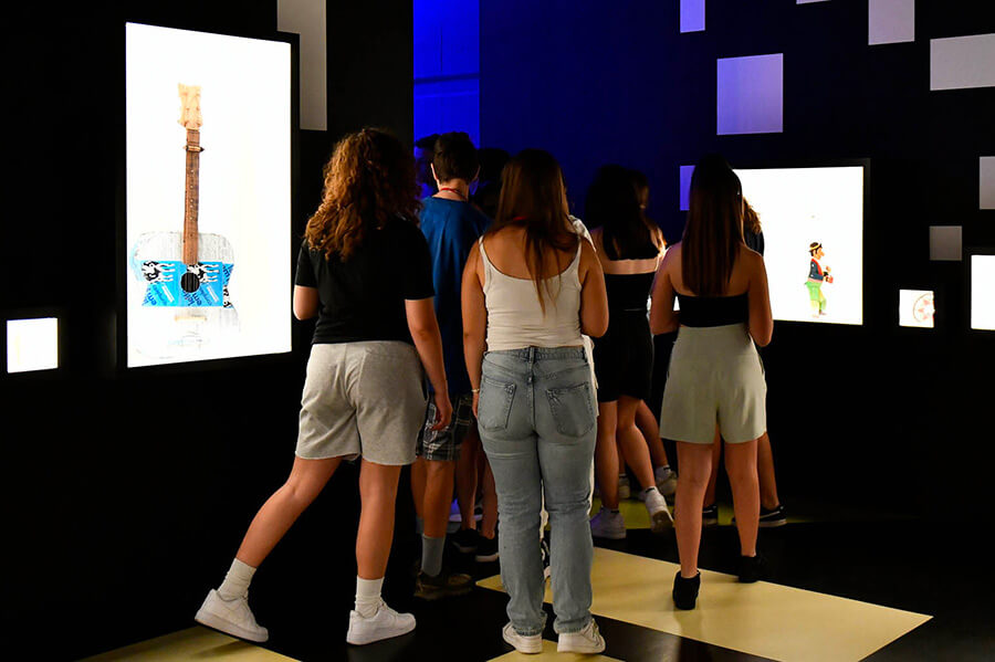 Public de dos regardant des œuvres dans des vitrines