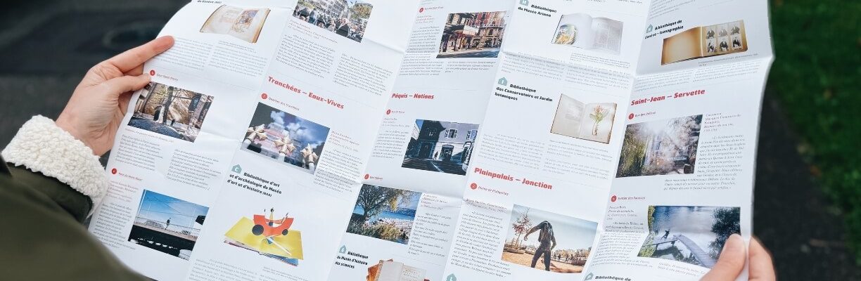 hands holding a leaflet of cultural trails with images of works and the neighbourhood in which they are located