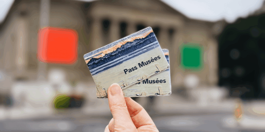 museum pass card held in a hand in front of a museum