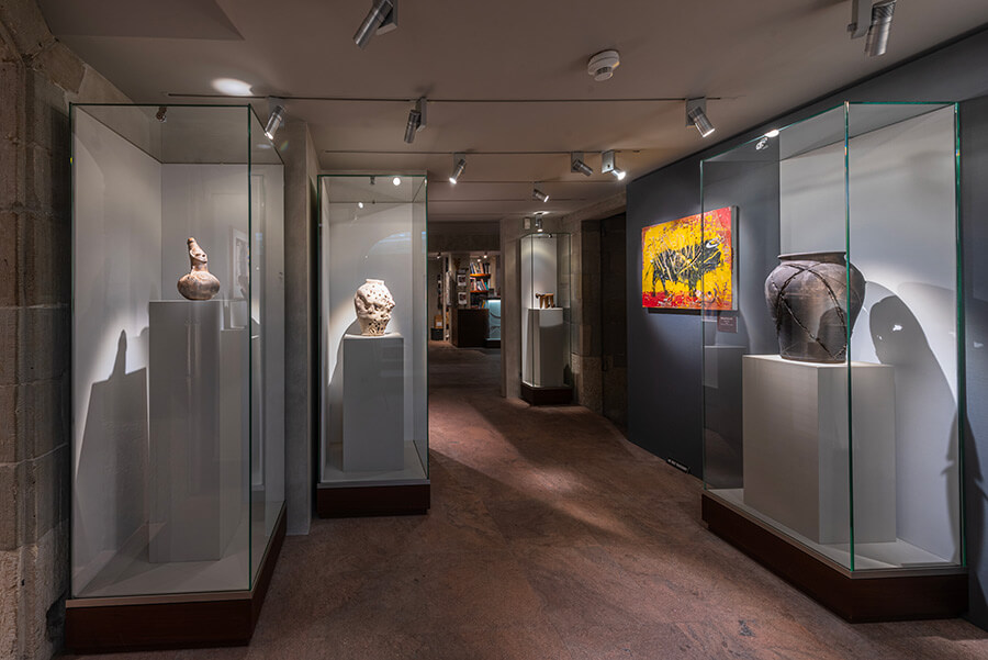 Oeuvres dans des vitrines avec un tableau d'un taureau noir sur fond jaune et rouge