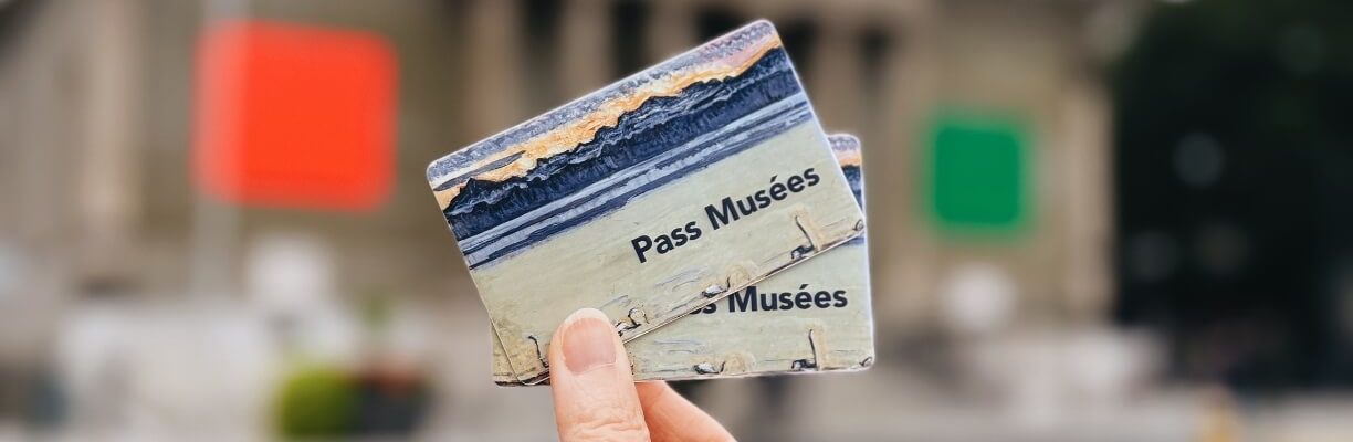 Deux Pass Musées tenus entre un pouce et un index