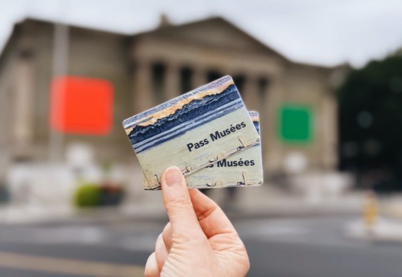 Deux Pass Musées tenus entre un pouce et un index