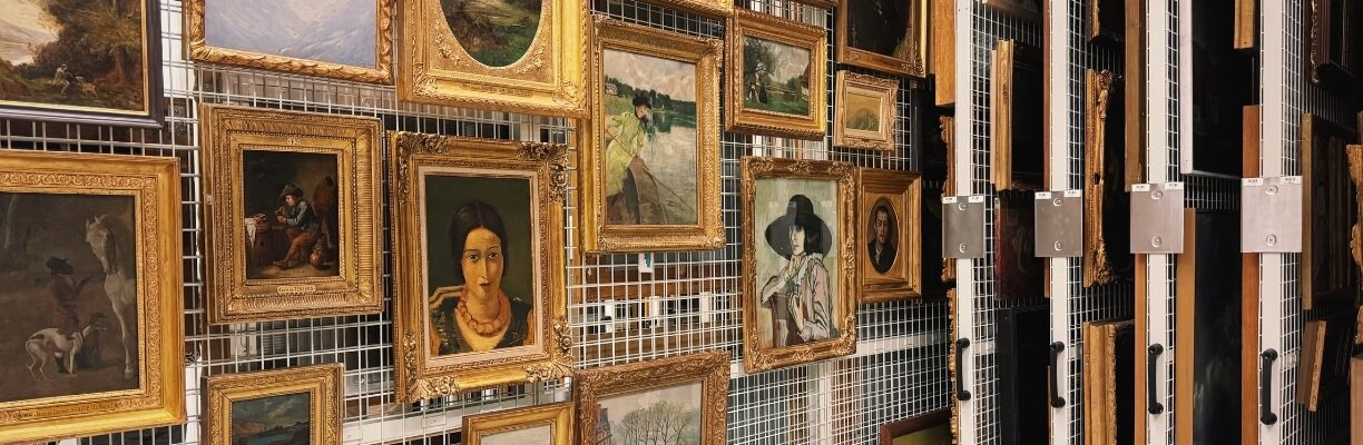 Vingtaine de peintures accrochée sur des parois amovibles au centre de conservation Carré Vert de la Ville de Genève