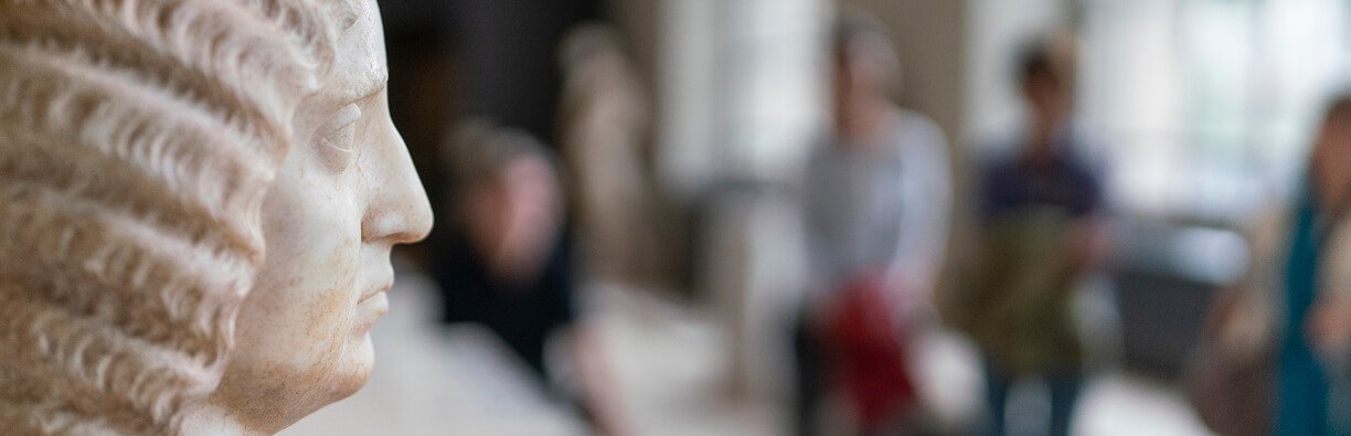 Tête de statue en marbre blanc sur la gauche de l'image, le reste de la photo est floue