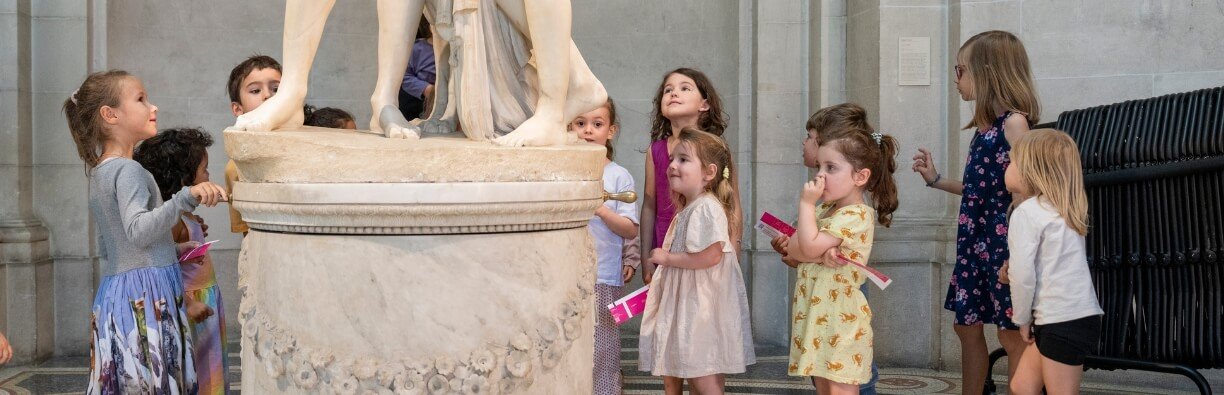 Young audience at the foot of a statue on a pedestal
