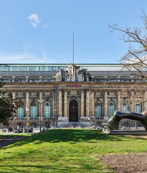 Statue, arbres et façade du MAH avec de décompte du temps, ciel bleu