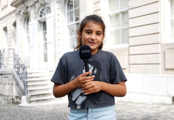 Petite fille tenant un micro devant le Musée de la Réforme