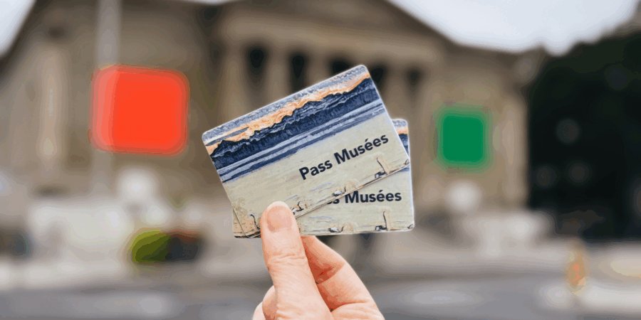 museum pass card held in a hand in front of a museum